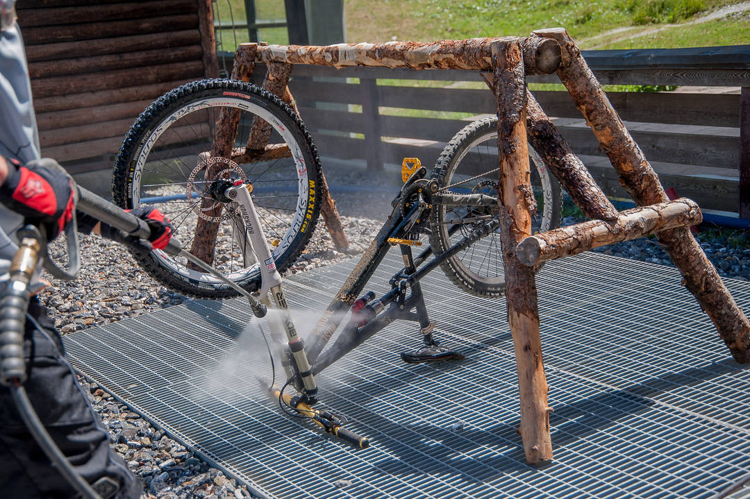 Mountainbike wird mit mobilen Hochdruckreiniger vom Schmutz befreit